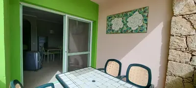 a table and chairs in a room with a green wall at Sal service green moradias residence with pool in Santa Maria