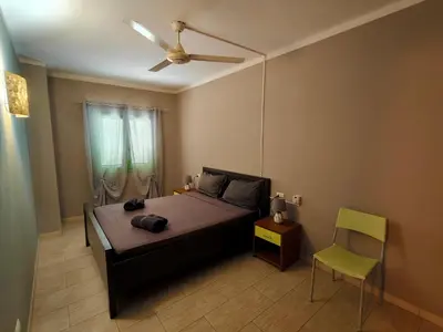a bedroom with a bed with a ceiling fan and a chair at Sal service green moradias residence with pool in Santa Maria