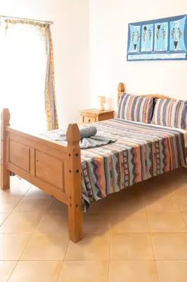 a bedroom with a wooden bed and a couch at Santa Maria Residence in Santa Maria