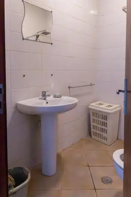 a white bathroom with a sink and a toilet at Santa Maria Residence in Santa Maria
