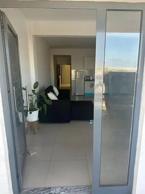 a living room with a couch and a glass door at Appartement avec Vue sur Mer à Praia, Wi-Fi, Navette Aéroport avec supplément in Praia