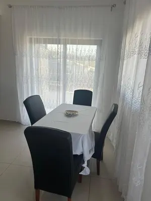 a table and chairs with a white table and a window at Appartement avec Vue sur Mer à Praia, Wi-Fi, Navette Aéroport avec supplément in Praia