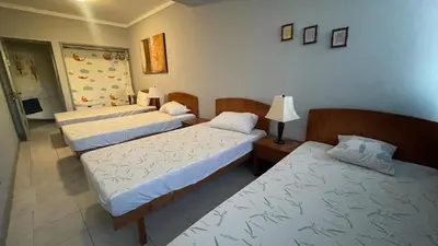 a room with three beds and a lamp at Girassol Tarrafal Apartment in Tarrafal