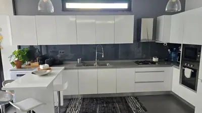 a kitchen with white cabinets and a sink at Family apartment with pool in Praia