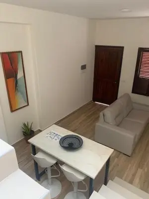 a living room with a table and a couch at Alana's loft in Praia