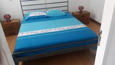 a bedroom with a blue bed with two pillows on it at FeliGrab in Mindelo