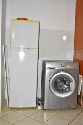 a refrigerator and a washing machine in a kitchen at Central Apartamento Fogo 101 in Santa Maria