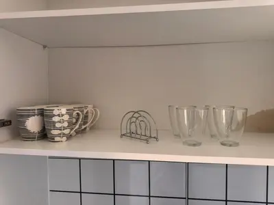 a kitchen counter with bowls and plates on it at Apartamento mais Carro George Mendes in Praia