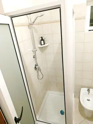 a shower with a glass door in a bathroom at Sea Breeze Apartment in Santa Maria