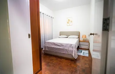 a small bedroom with a bed and a wooden floor at Cozy and beautiful apartment! in Praia