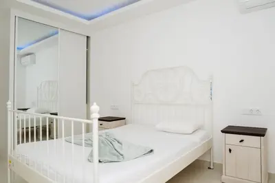 a white bedroom with a white bed and a mirror at Spacious 3-Bedroom Apt Near Kebra Kanela Beach in Praia