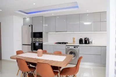 a kitchen with a table and chairs and a stove at Spacious 3-Bedroom Apt Near Kebra Kanela Beach in Praia