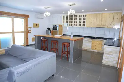 a living room with a couch and a kitchen at Moreira Estates