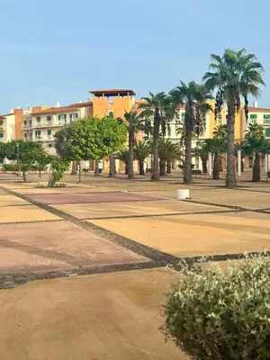 a park with palm trees and a large building at Studio with pool in Santa Maria