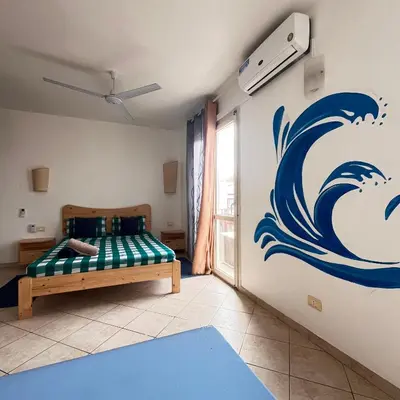a bedroom with a bed with a painting of a wave at Urban Studio Plaza 6 in Santa Maria
