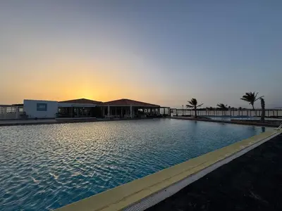 a large swimming pool with a sunset in the background at Murdeira V17 I by RPG Group in Beirona