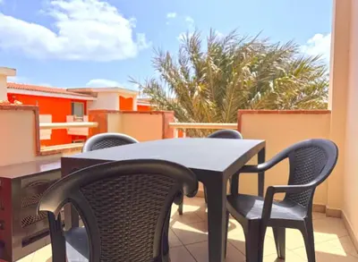 a table and chairs sitting on a balcony at Morabeza Santa Maria - Djadsal Moradias in Santa Maria
