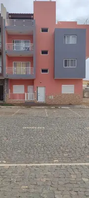 a pink building with a parking lot in front of it at Sams House in Espargos
