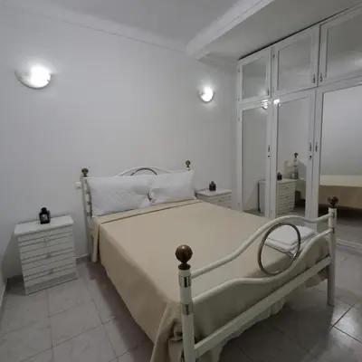 a white bedroom with a bed and a dresser at HOSTEL Terra Branca in Praia