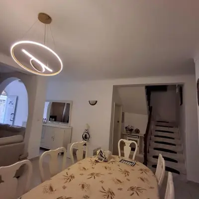 a dining room with a table and chairs and a staircase at HOSTEL Terra Branca in Praia
