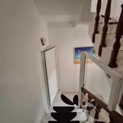 a hallway with a staircase with a door and a stair case at HOSTEL Terra Branca in Praia