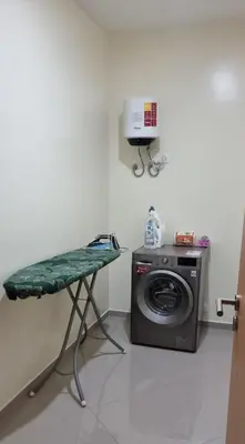 a laundry room with a washing machine and a table at Palmarejo Center Apartment Suites in Praia