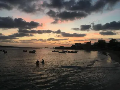 two people are standing in the water at sunset at Casa Relaxa in Sal Rei