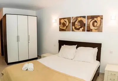 a bedroom with a bed and a white cabinet at HostySpot - Melia Dunas in Santa Maria