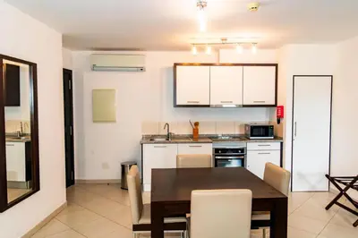 a kitchen with a table and chairs in a room at HostySpot - Melia Dunas in Santa Maria