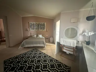a bedroom with a bed and a table and a rug at Tropical Mediterraneo in Santa Maria