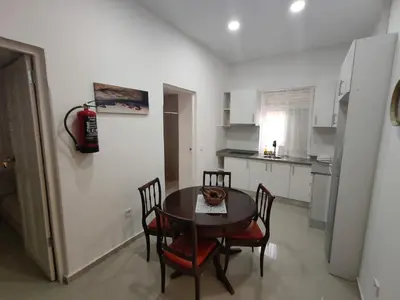 a kitchen with a table and chairs and a refrigerator at Vivenda Paraíso, Charming house on the Plateau in Praia