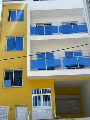 an apartment building with blue balconies at Appartement Praia Sao Felipe in Praia