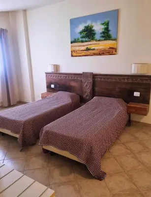 a room with two beds and a picture on the wall at Tropical Resort Pool View - Apartment in Santa Maria