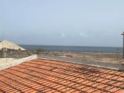 a tile roof on a beach with the ocean in the background at Casa Ida 1 Tarrafal, Santiago, Cabo Verde in Tarrafal
