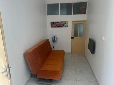 a living room with a brown couch and a door at Casa Ida 1 Tarrafal, Santiago, Cabo Verde in Tarrafal