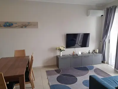 a living room with a tv and a dining room table at Boavista Estoril Residence Sol & Mar in Sal Rei