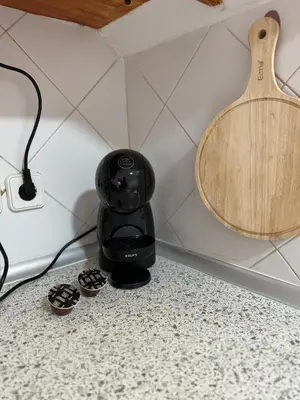 a black coffee maker on a counter next to some cupcakes at Murdeira V17 RC by RPG Group in Beirona