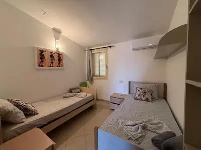 a small room with two beds and a window at Casa Mendonça in Santa Maria
