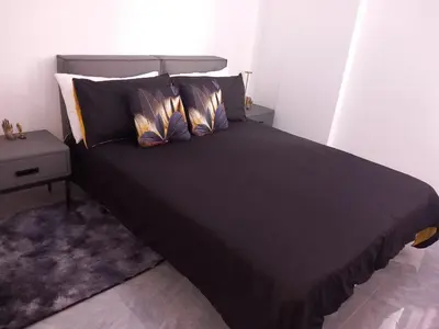 a bed with black sheets and pillows in a room at Sal Rei ,Boavista Magic Apartment - in Sal Rei