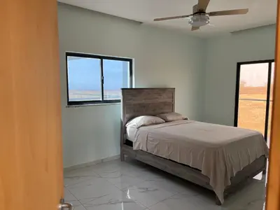 a bedroom with a bed and two windows at Ponta de mar in Praia