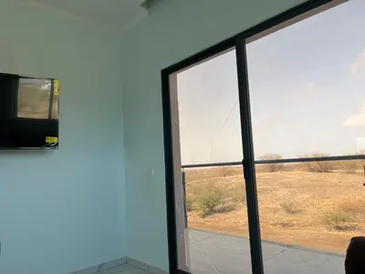 a window with a view of a field through it at Ponta de mar in Praia