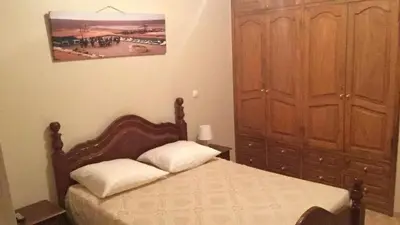 a bedroom with a bed and a wooden cabinet at Comfortable private room in Assomada in Assomada