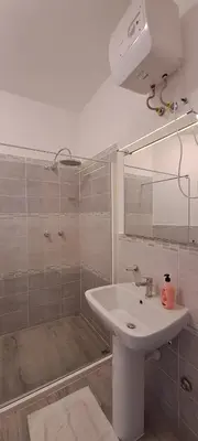 a bathroom with a sink and a shower with a mirror at Bungalow Praia de Chaves Sol & Mar in Cabeçadas