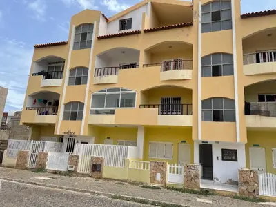 a yellow building with white fences in front of it at Holiday Sal Island in Santa Maria
