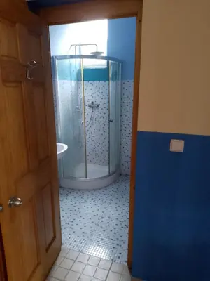a bathroom with a shower with a glass door at Djabraba's Trail Triple SUITE in Vila Nova Sintra