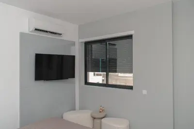 a white room with a window and a tv at Santa Ocean View in Mindelo