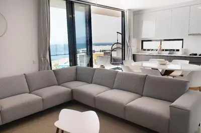 a living room with a gray couch and a kitchen at Santa Ocean View in Mindelo