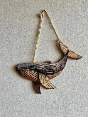 a wooden whale ornament hanging on a wall at Tropical Mar Profundo in Santa Maria