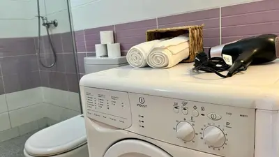 a bathroom with a washing machine and a toilet at Estrella Do Mar Santa Maria in Santa Maria