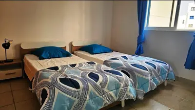 two beds in a room with blue pillows at A1-5101- 3 Bedroom Seaview Apartment in Cape Verde in Sal Rei
